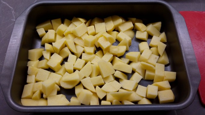 Chopped potatoes in oven tray